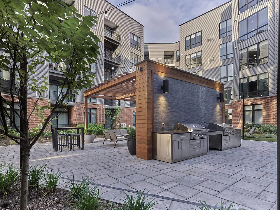 The Breton, multifamily by HH Designers in Bayonne, NJ, courtyard grilling pavilion at dusk