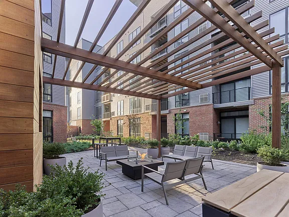 The Breton, multifamily by HH Designers in Bayonne, NJ, pergola lounge with fire pit