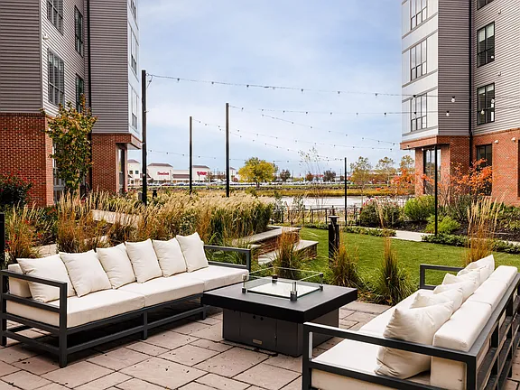 The Breton, multifamily by HH Designers in Bayonne, NJ, terrace lounge with fire table