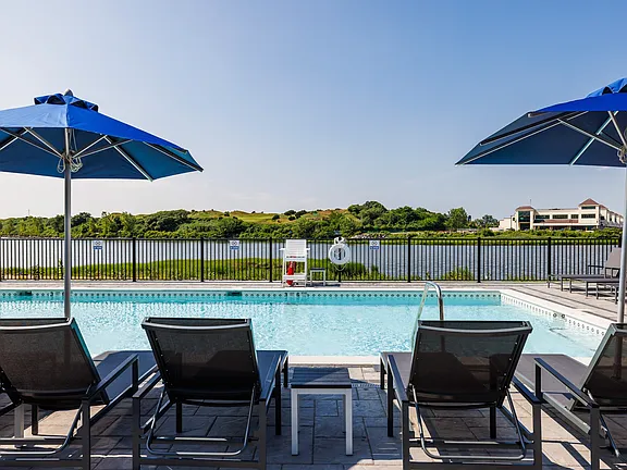 The Breton, multifamily by HH Designers in Bayonne, NJ, poolside loungers facing the water