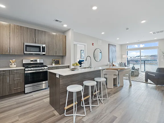 The Breton, multifamily by HH Designers in Bayonne, NJ, kitchen island open to the living space