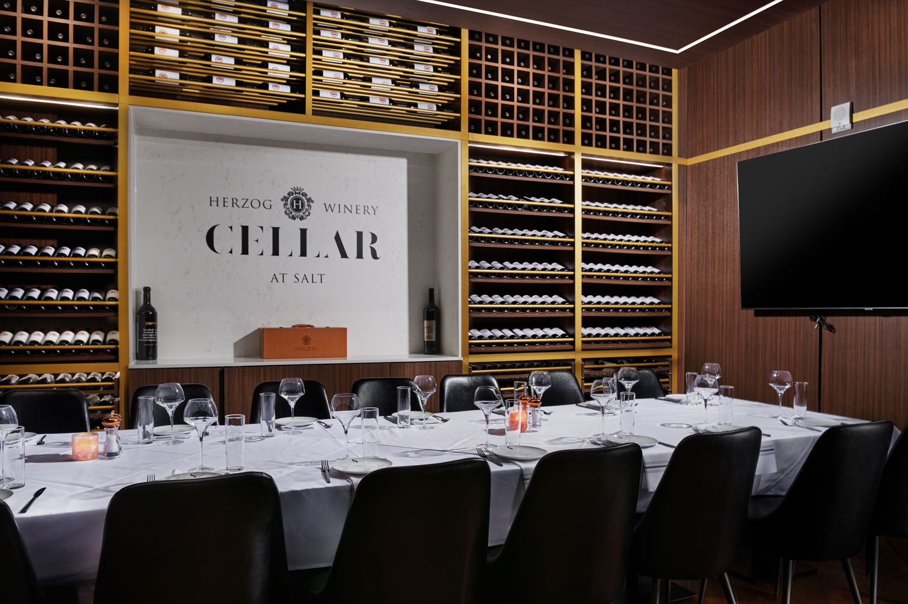 The Herzog Winery Cellar at SALT: private wine room lined with bottle walls around a single long table